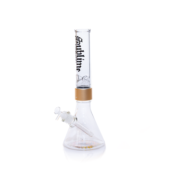 Official Prism x Sublime collaborative modular water pipe featuring a clear glass beaker base with the iconic yellow sun logo by Opie Ortiz on the bottom. This customizable bong includes a metallic gold Halo Connector and a white glass straight tube mouthpiece adorned with the black Sublime gothic logo and Long Beach, California text.